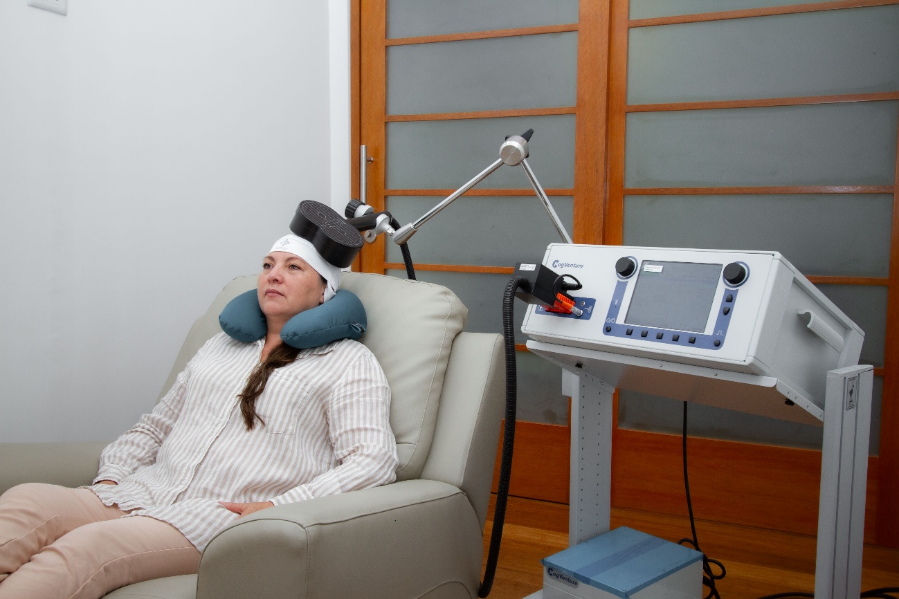 Paciente en una sesión de estimulación magnética transcraneal repetitiva (EMTr) con equipo MagVenture, en investigación para deterioro cognitivo y Alzheimer